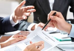 Profissionais analisando gráficos e estratégias durante reunião de planejamento de marketing, com foco em resultados e performance – Agência Mais Resultado.