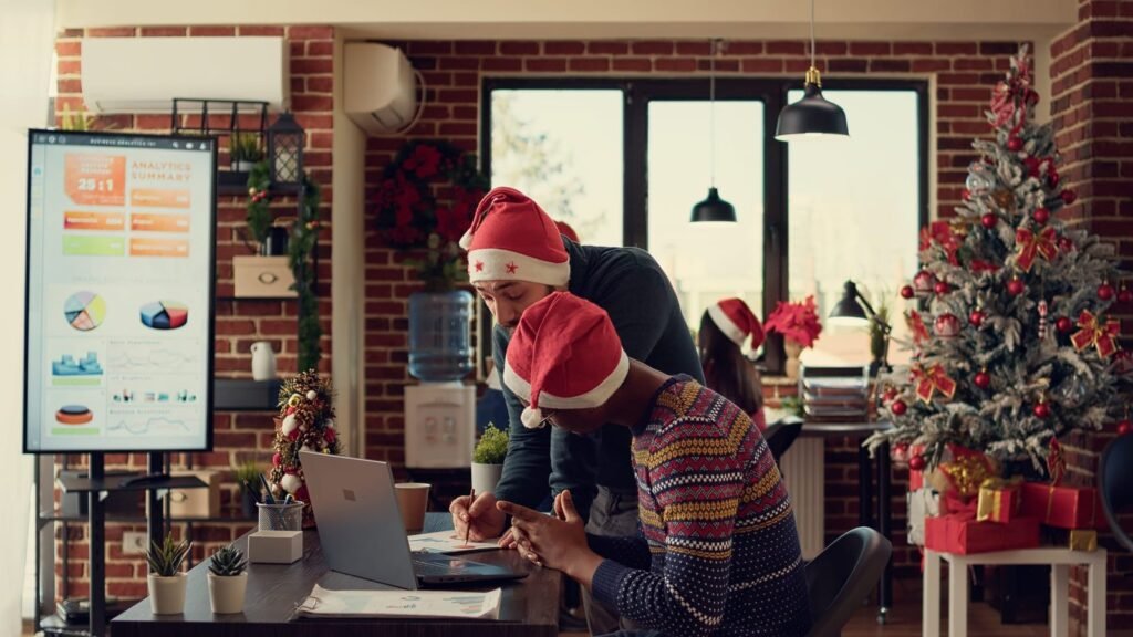Equipe de marketing planejando campanhas de Natal e Ano Novo em um escritório decorado com temas natalinos.