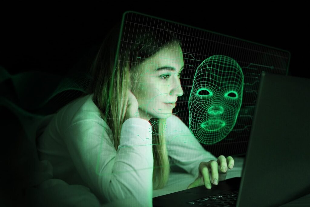 Mulher observando tela de notebook com projeção digital de uma face em 3D, representando inteligência artificial, reconhecimento facial e transformação digital no marketing — conceito explorado pela Agência Mais Resultado.