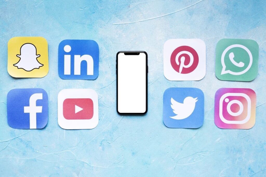 Ícones das principais redes sociais ao redor de um smartphone, representando a escolha das plataformas digitais ideais para negócios. A Mais Resultado ajuda você a maximizar sua presença digital.