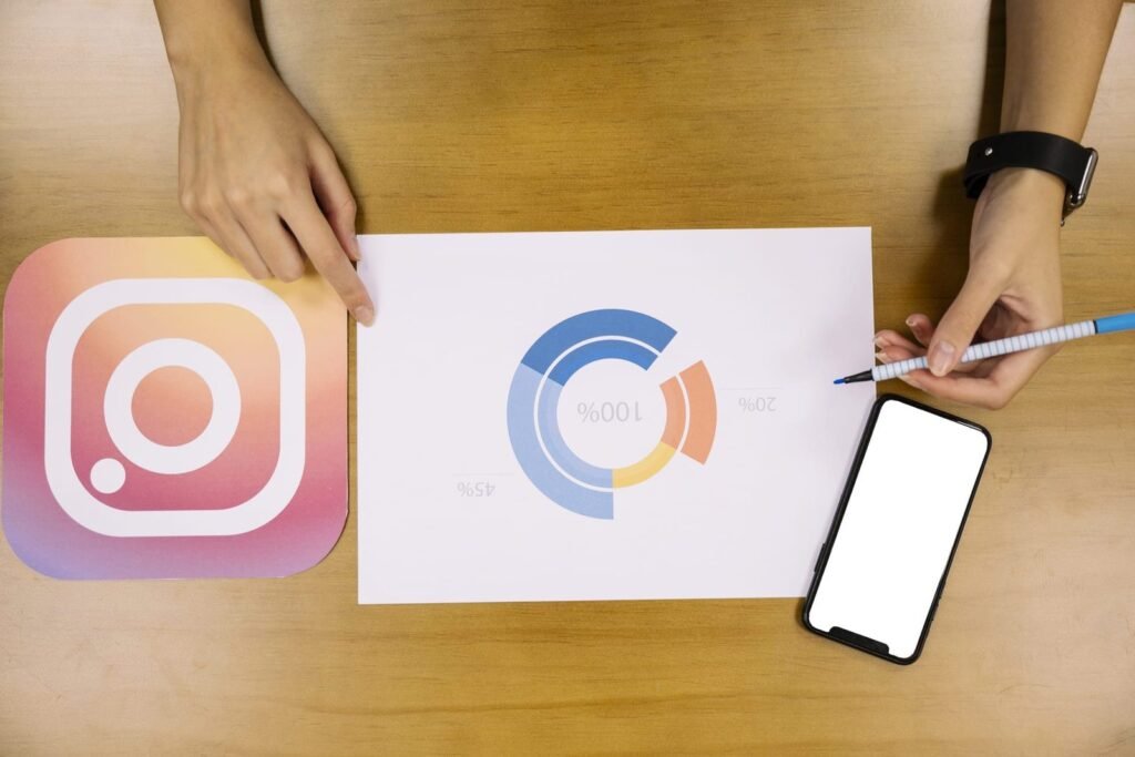 Gráfico de análise de alcance no Instagram com um smartphone e o logotipo da rede social sobre uma mesa.