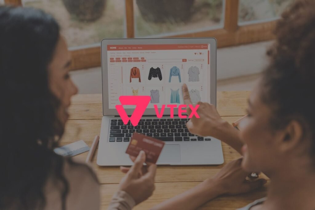 Duas mulheres fazem compras online em um e-commerce VTEX, analisando produtos em um laptop.