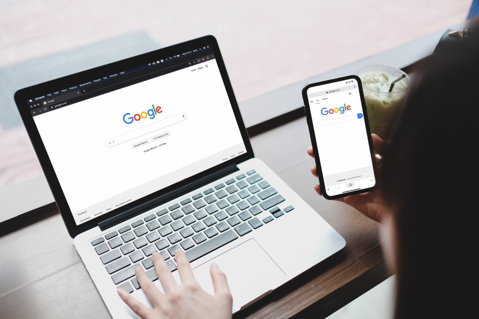 Pessoa usando laptop e celular para acessar o Google, simbolizando a importância de estratégias de SEO para aumentar a visibilidade online.