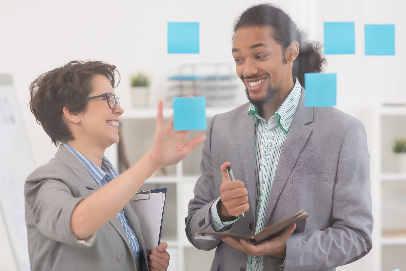 Dois profissionais em reunião estratégica com post-its, planejando ações de marketing de experiência para fidelização de clientes – Agência Mais Resultado.